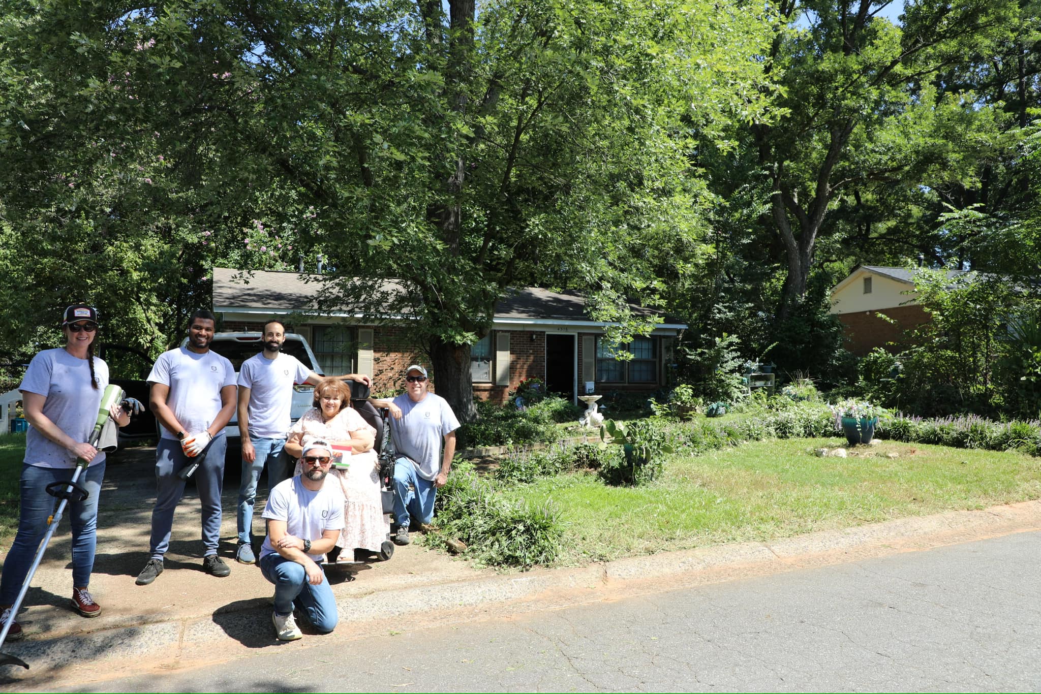 Green Machine volunteers in Charlotte NC during a monthly service day, with in-kind equipment gifted to homeowners for ongoing maintenance