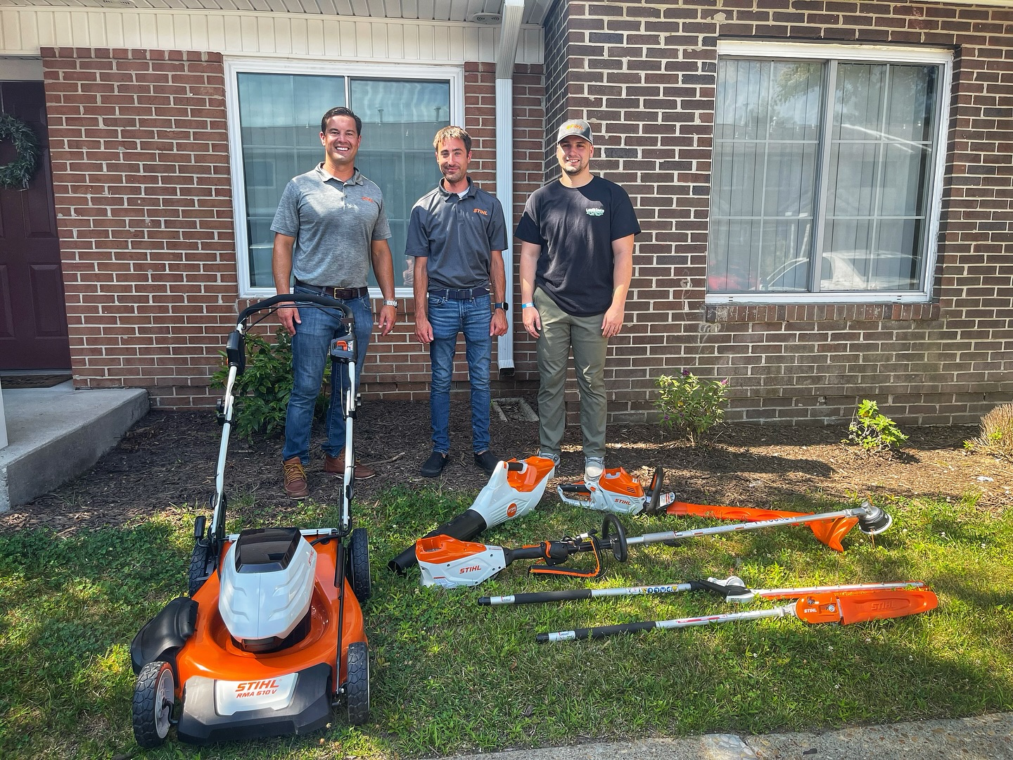 Three IWTMYL volunteers including Max displaying partner-supported STIHL battery-powered lawn equipment