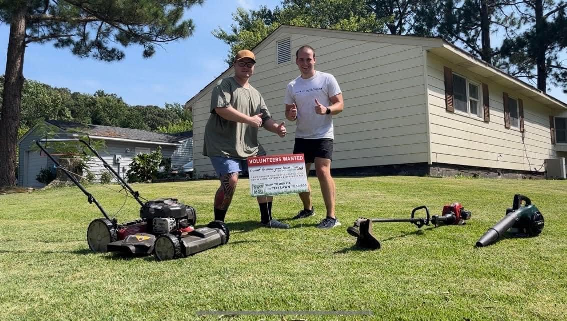 I Want To Mow Your Lawn volunteers beside a yard sign after a free service visit