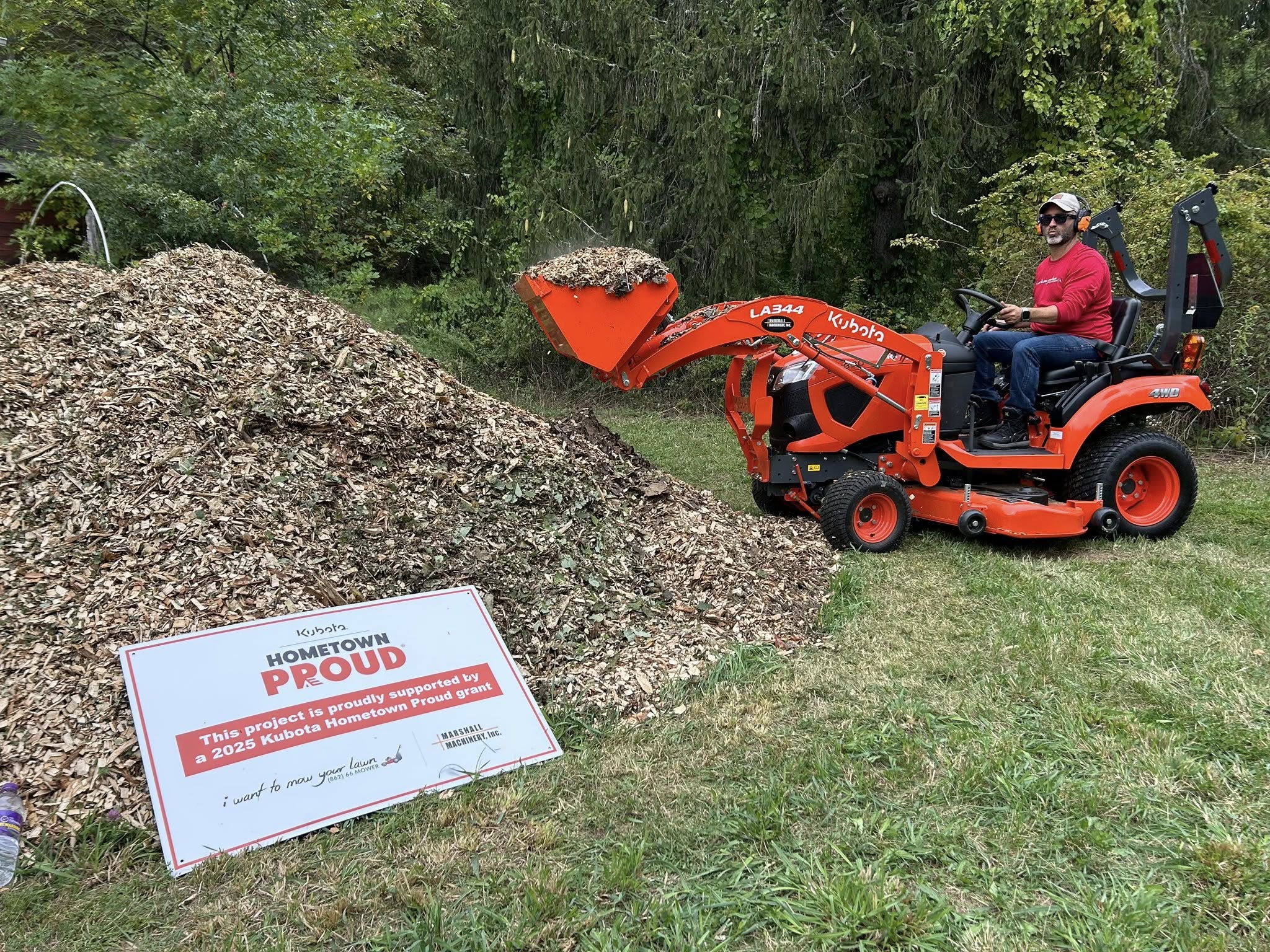 Kubota compact tractor with front loader being used during a community service day.